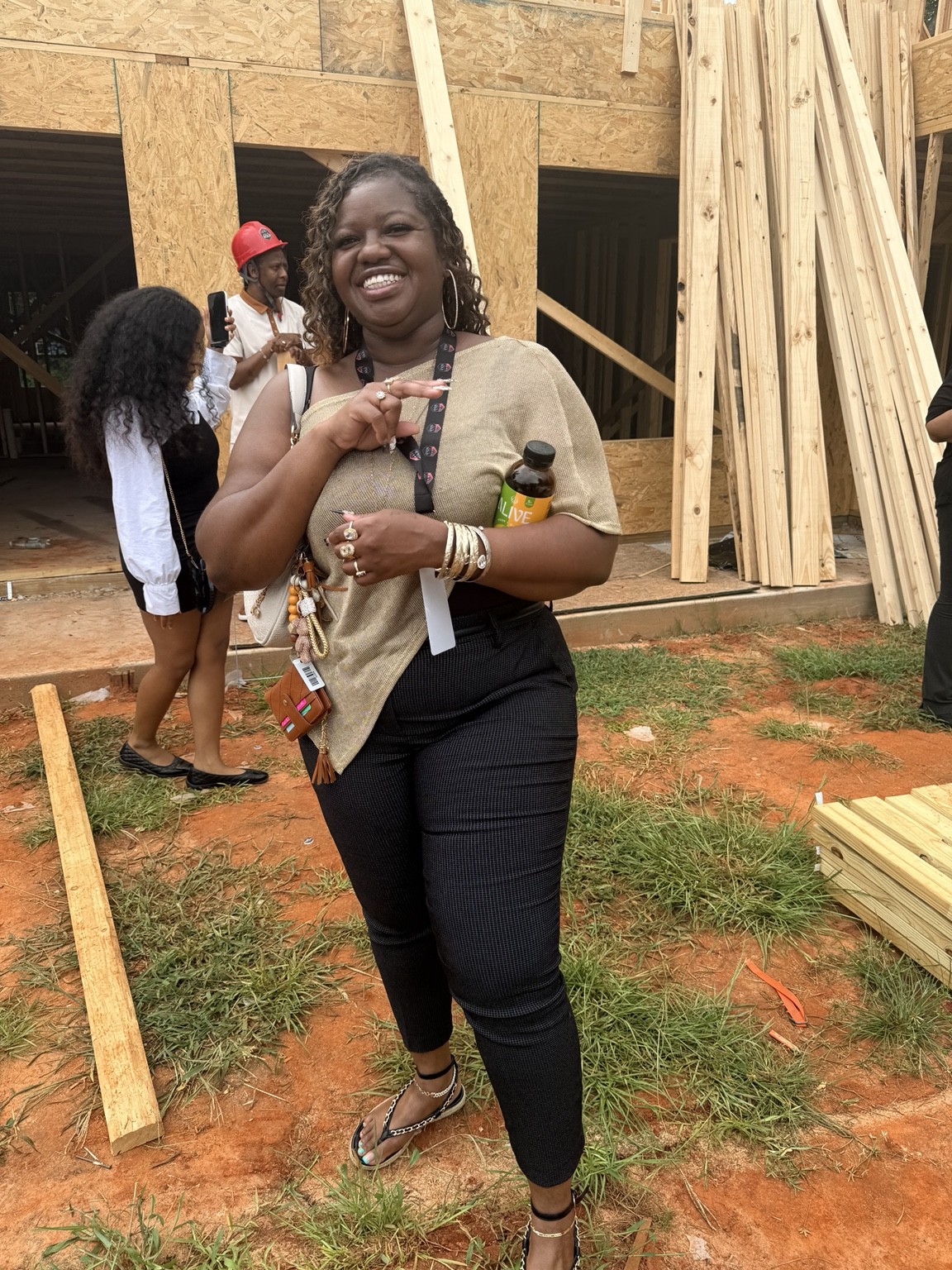 Shonte smiling beside a building under construction